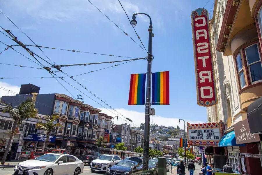 Das Castro-Viertel von San Francisco mit dem Castro-Theater-Schild und Regenbogenfahnen im Vordergrund.